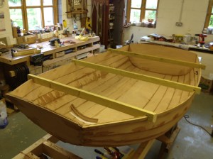 Scrap wood with slots to fit over the plank edges keeps the hull shape